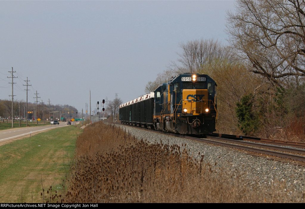 D702 heads for Wyoming Yard with a short train of bottom ash gondolas off the Michigan Shore